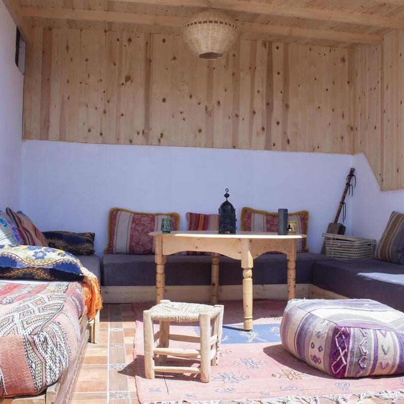 The cushioned lounge under the wooden roof at Afer Surf